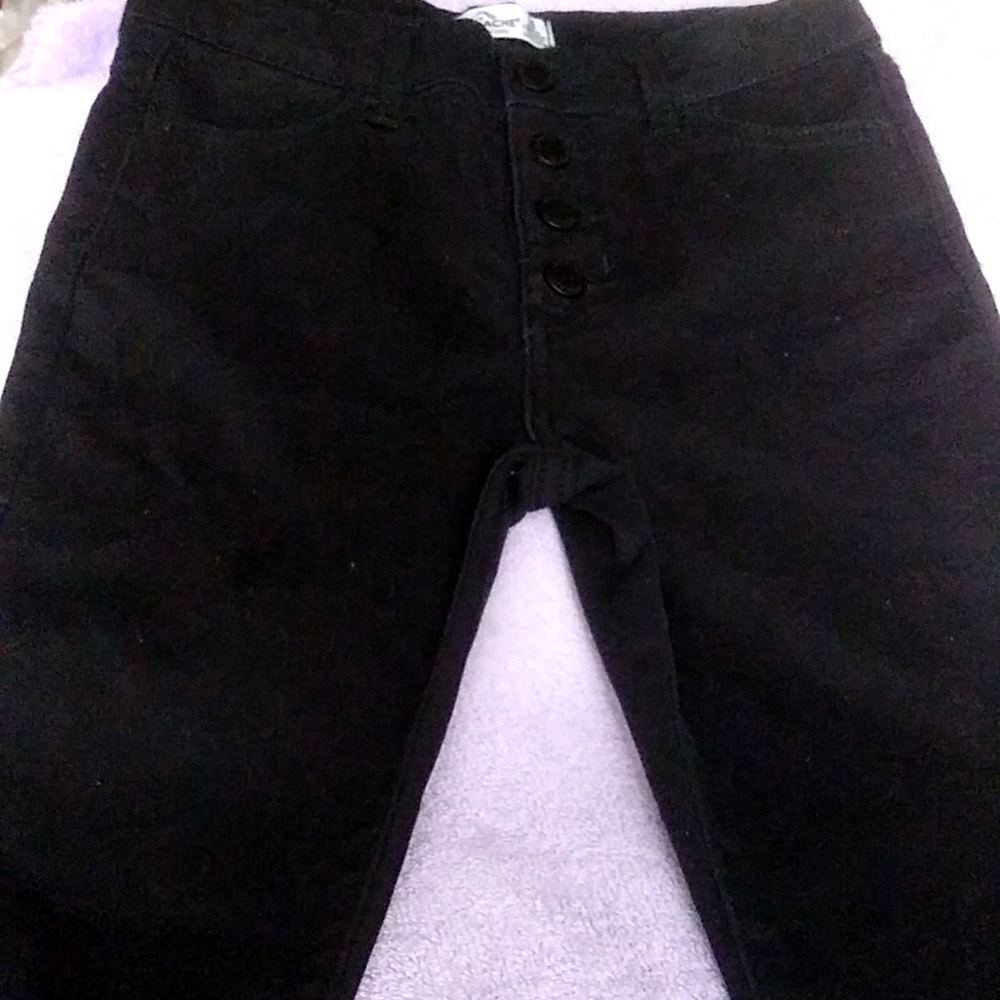 Black skinny jeans with four snaps in the front of them